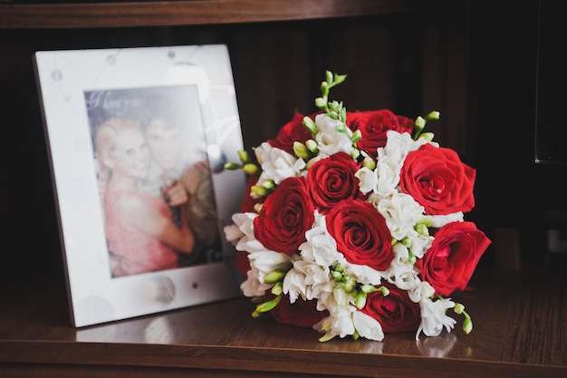 Bouquet e porta-retratos na mesa 7875