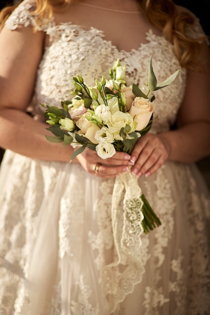 Bouquet nas mãos da noiva, mulher se preparando antes da cerimônia de casamento