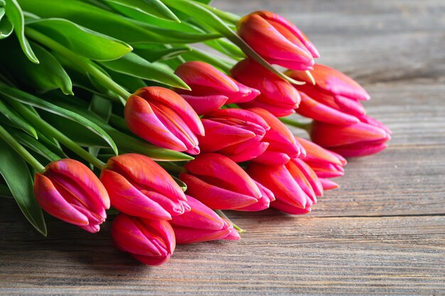 Bouquet von rosa Tulpen auf einem hölzernen Hintergrund Konzept von Muttertag Frauentag Frühling