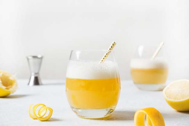 bourbon con jugo de limón, jarabe de azúcar y clara de huevo mezclado en vaso