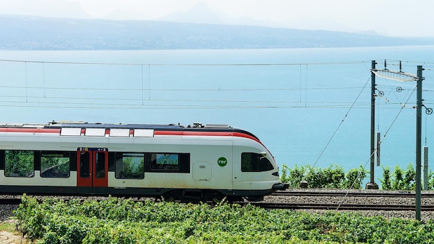 Bourg-en-Lavaux, Suíça - 30 de agosto de 2016: Trem em execução na ferrovia perto da trilha de caminhada Lavaux Vineyard Terraces no Lago Genebra e montanhas suíças, distrito de Lavaux-Oron, Suíça