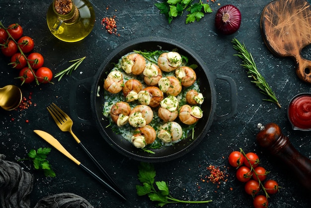 Bourgogne Escargot Caracóis com queijo de alho em molho cremoso em uma placa de pedra preta Vista superior Espaço livre para texto