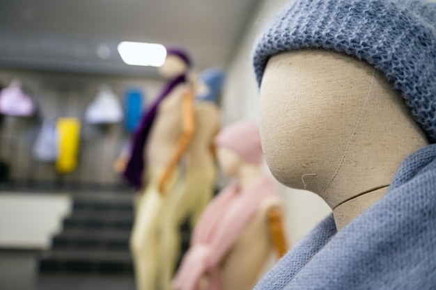 Boutique con maniquíes de moda femenina con gorros y bufandas de invierno