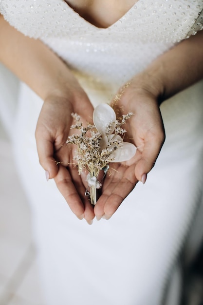 Boutonniere branco nas mãos da noiva