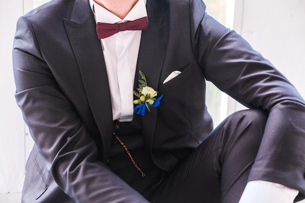 Foto boutonniere im anzug des bräutigams. bräutigam posiert