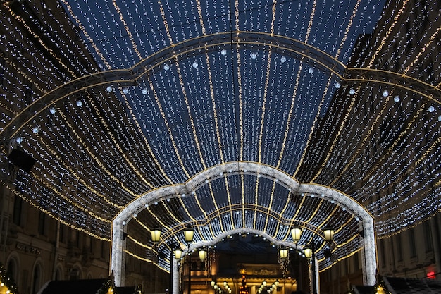 bóveda arqueada de guirnaldas de luces y luces de linterna en el fondo del cielo nocturno