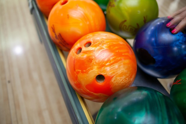 Bowlingkugeln aus nächster Nähe. Bahnen mit Bällen und Stiften zum Bowling. Ein lustiges Spiel für das Unternehmen.