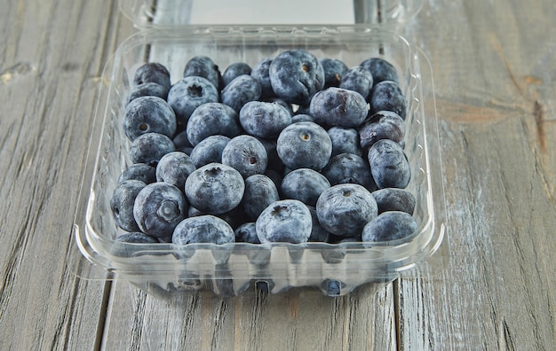 Box mit ausgewählten Heidelbeeren auf Holzhintergrund