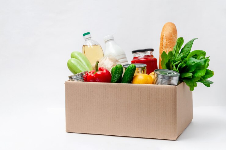 Foto box mit lebensmitteln. grundnahrungsmittel: öl, konserven, getreide, milch, gemüse, obst