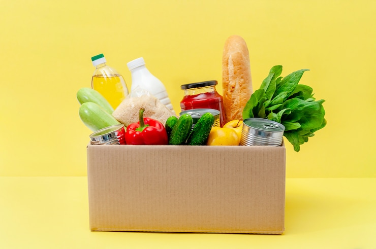 Foto box mit lebensmitteln. grundnahrungsmittel: öl, konserven, getreide, milch, gemüse, obst