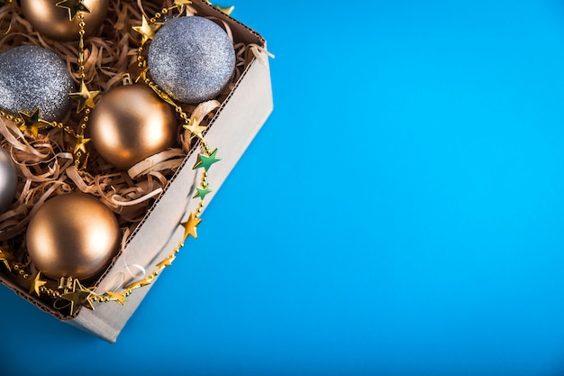 Box mit silbernen und goldenen Weihnachtsspielzeugen