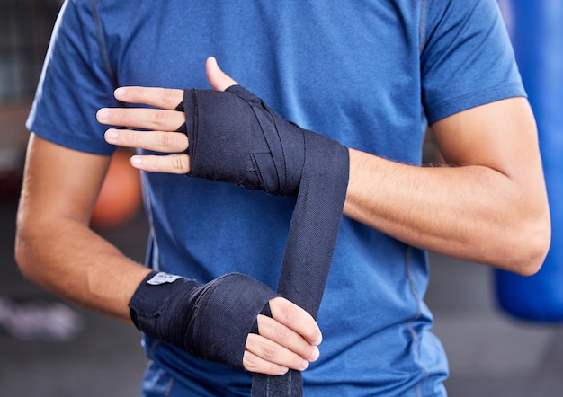 Boxe fitness e fita com as mãos do homem na academia para treino esportivo e treinamento de artes marciais Exercício forte e bem-estar com boxer e bandagem na aula de mma para saúde ou desempenho de luta