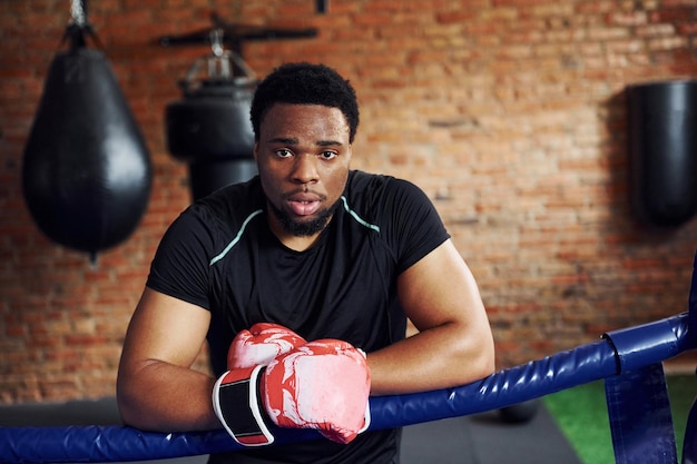 Boxeador afroamericano fuerte en ropa deportiva tiene práctica en el gimnasio
