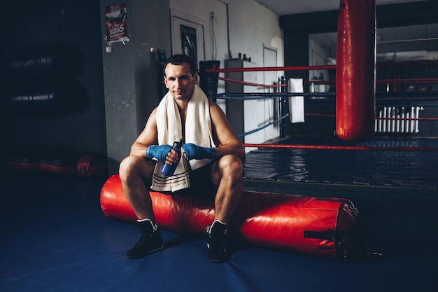 Foto un boxeador bebe agua mientras entrena en un gimnasio