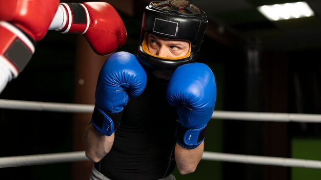 Foto boxeador com capacete e luvas treinando