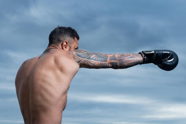 Boxeador entrenando al aire libre boxeador masculino entrenando defensa y ataques en guantes de boxeo boxer punch