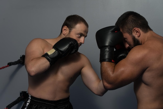 Boxeador forte e seu oponente durante uma luta de caixa em um ringue