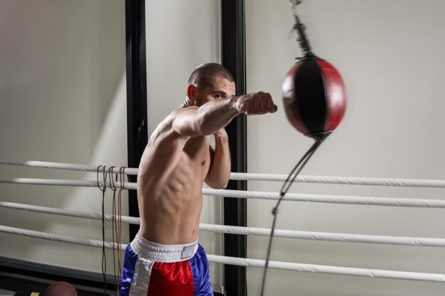 Un boxeador con guantes en la sala de entrenamiento del boxeador patada en el gimnasio