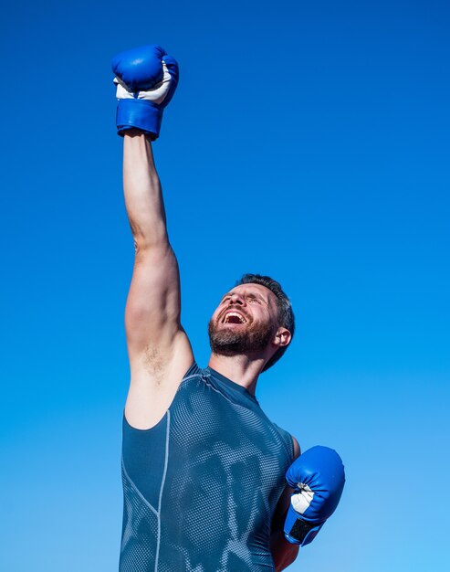 Boxeador de hombre en el estadio. gimnasio al aire libre. chico atlético musculoso entrenando en guantes de boxeo. éxito deportivo. ropa deportiva de fitness masculino. deportista sobre fondo de cielo. Atleta guapo maduro.