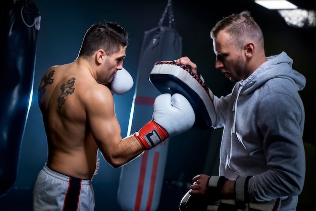 Foto boxeador masculino aprendiendo con entrenador