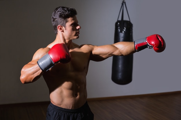 Boxeador masculino atacando con su izquierda en el club de salud