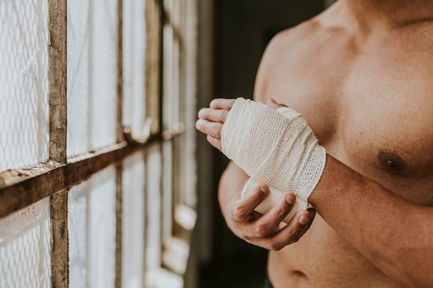 Foto boxeador masculino colocando uma alça na mão