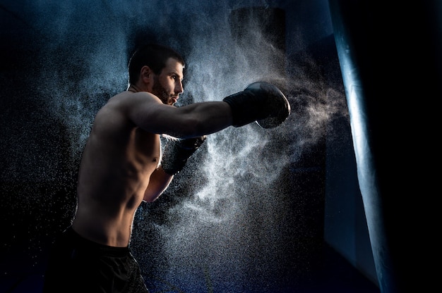 Boxeador masculino en saco de boxeo