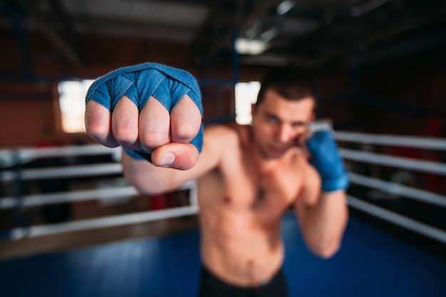 Boxeador en muñequera azul en el entrenamiento.