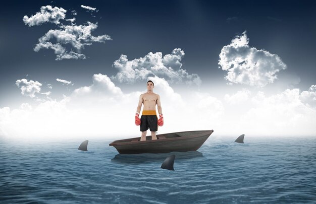 Boxeador de pie contra tiburones dando vueltas en bote pequeño en el mar