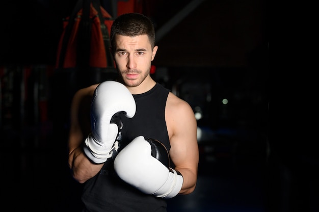 Boxeador seguro de pie en pose y listo para luchar.