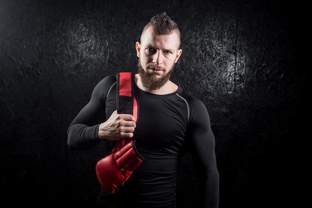 Un boxeador sosteniendo su brillo en el hombro después del entrenamiento en el gimnasio.