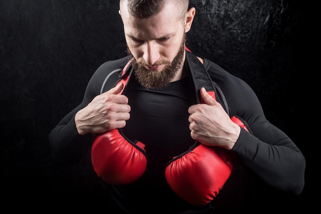 Un boxeador sosteniendo su brillo en el hombro después del entrenamiento en el gimnasio.