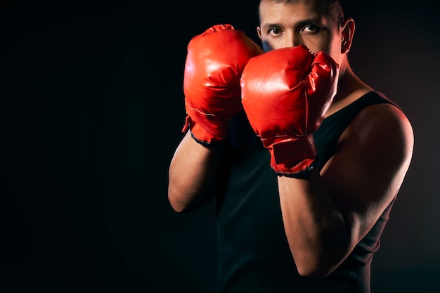 Un boxeador usa guantes de boxeo para hacer ejercicio y entrenar para boxear