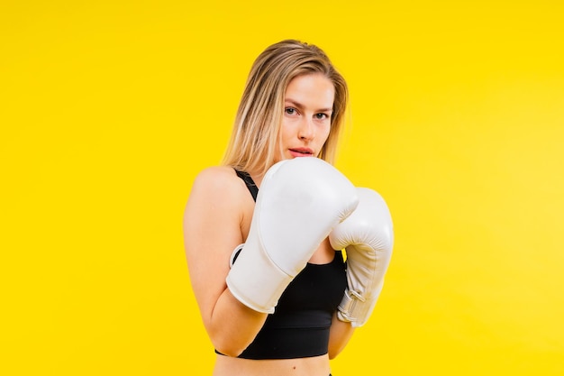 Boxeadora batendo em um estúdio de boxe mulher com luvas treinando duro