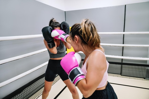 Boxeadora golpeando a su oponente en la cara durante una práctica en el ring