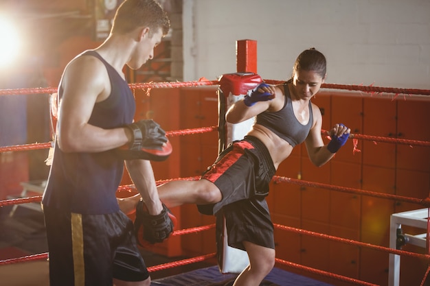 Boxeadora practicando kickboxing con entrenador su entrenador