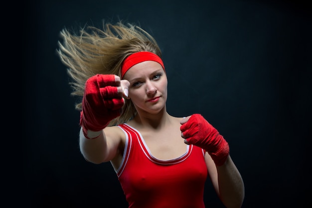 Boxeadora en ropa deportiva y vendas de boxeo rojo