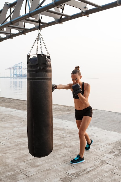 Boxeo de formación deportiva hermosa joven en la playa.