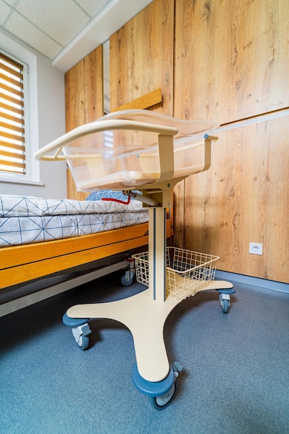 Boxeo para recién nacidos. Cámara para madres y recién nacidos. Portabebés en el hospital de maternidad. Sala de posparto en la maternidad. Cama vacía para recién nacido. De cerca.