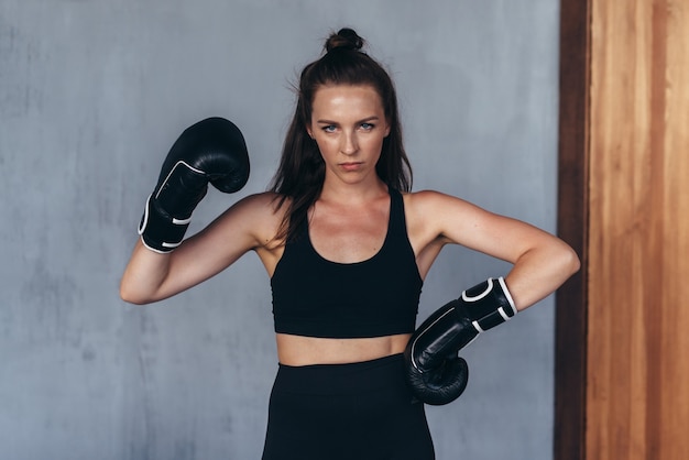 Boxer amador feminino posa em luvas de boxe.