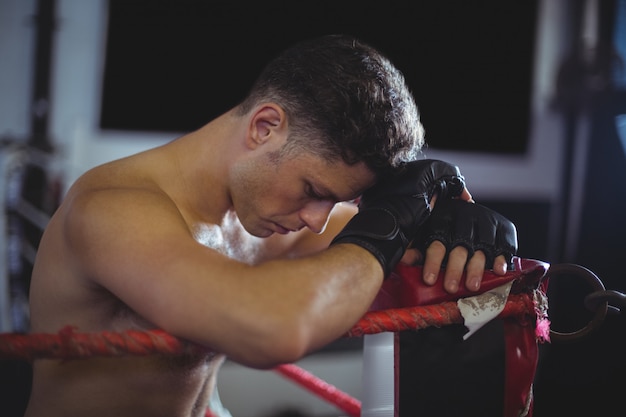 Boxer apoyándose en el ring de boxeo