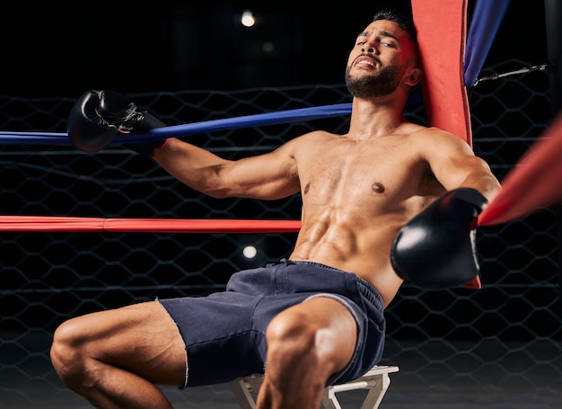 Boxer de fitness e homem cansado no canto do ringue exausto da luta de boxe esportiva na academia ou arena homem ativo na fadiga do clube de luta e relaxando do treino ou exercício intenso do esporte de luta