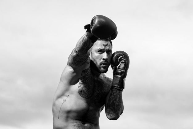 Boxer entrenamiento boxeador masculino al aire libre formación defensa y ataques en guantes de boxeo boxi muscular fuerte