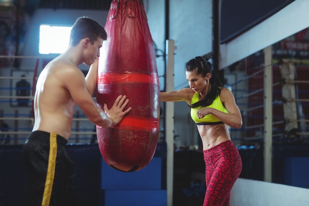 Boxer fêmea praticando boxe com saco de boxe