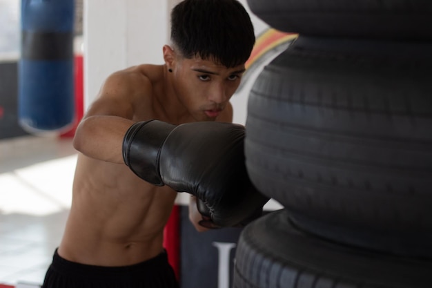 Boxer mexicano latino com luvas em treinamento no ginásio de boxe