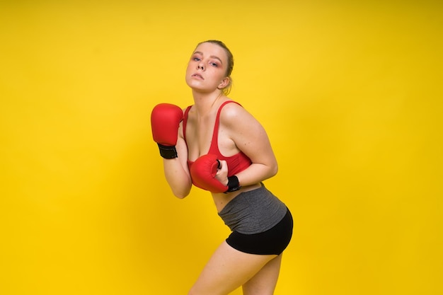 Boxer seductora confiada boxeadora con guantes estudio deportivo mujer posando mirando a la cámara