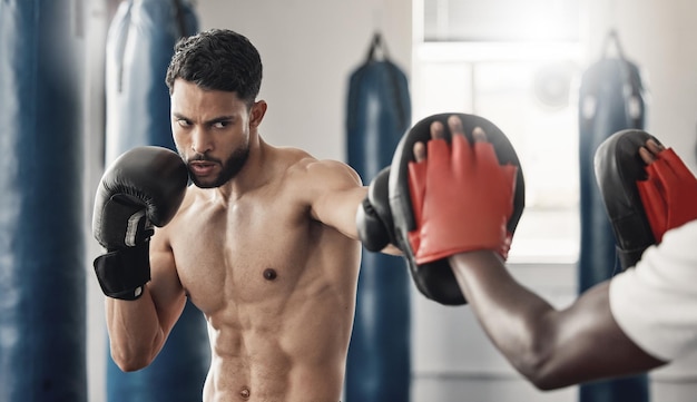 Boxpad-Sportler und Fitnessstudio-Übungscoaching mit Personal Trainer-Experten für Turniere Starker muskulöser und harter MMA-Athlet, der Fitnessübungen für Wohlbefinden und Schlagdisziplin durchführt