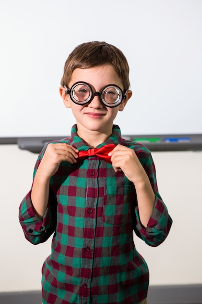 Foto boy atar el arco mientras está de pie en el aula