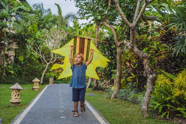 Boy lanzar una cometa en el parque en la isla de Ubud, Bali, Indonesia