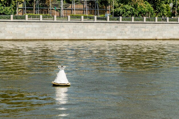 Foto boya blanca en las olas del río en el fondo de la orilla del río